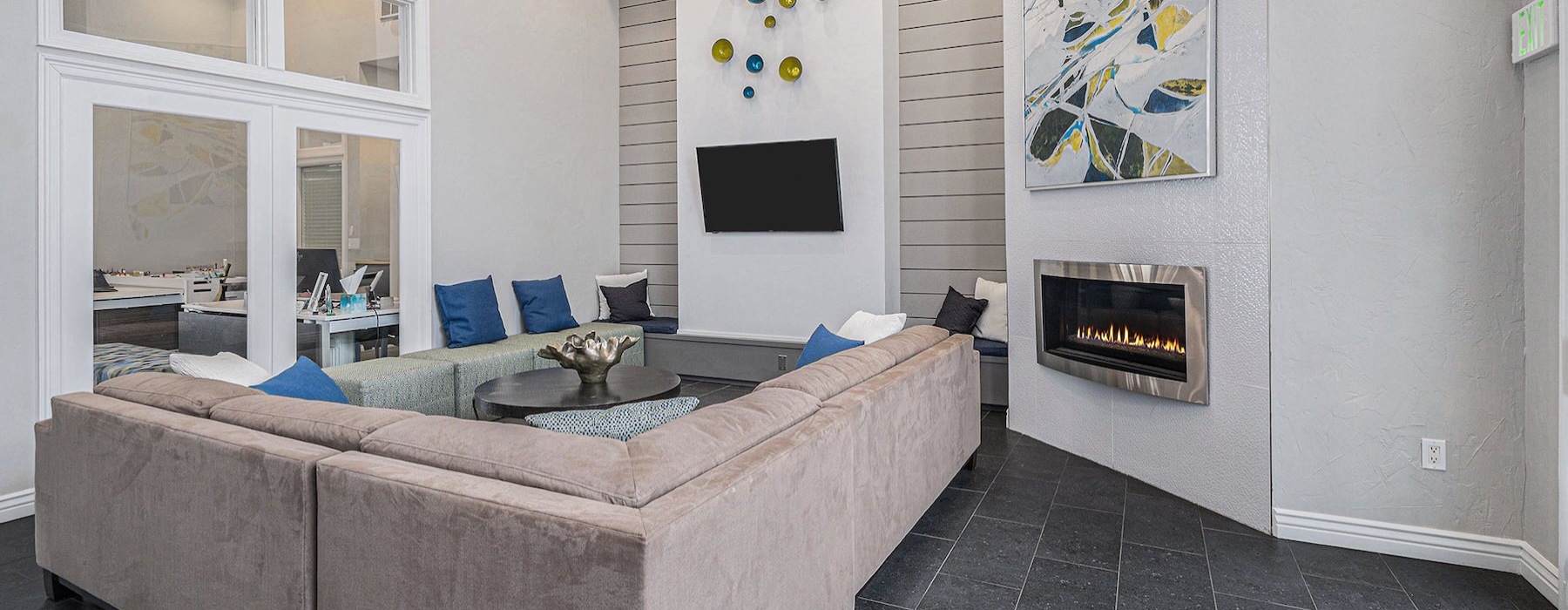 a clubroom with a couch, tv and a fireplace